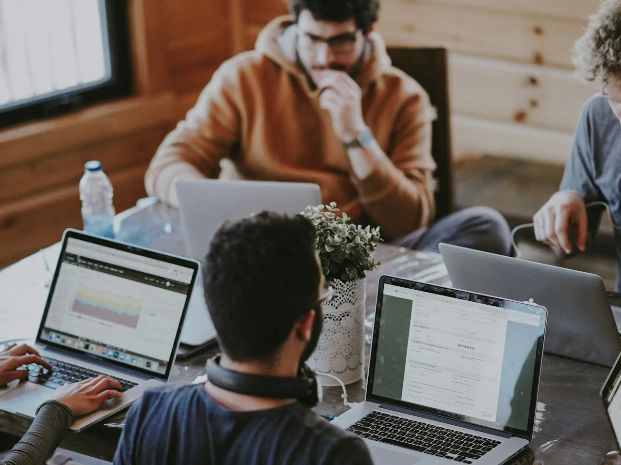 A team collaborating around laptops in a shared workspace.