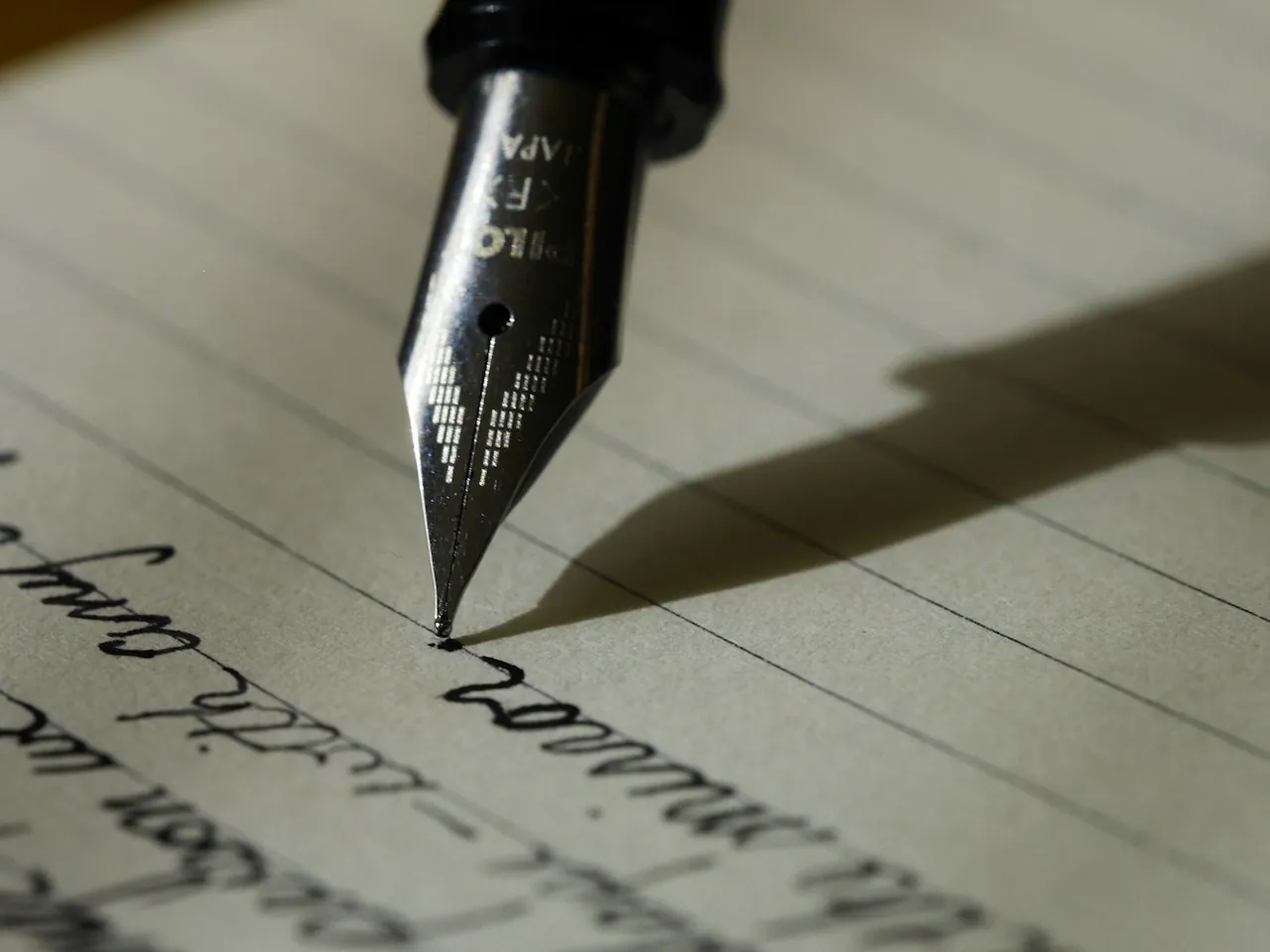 A fountain pen writing on lined paper.